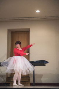 Living Light dancer at a recital in a red leotard with white ruffing