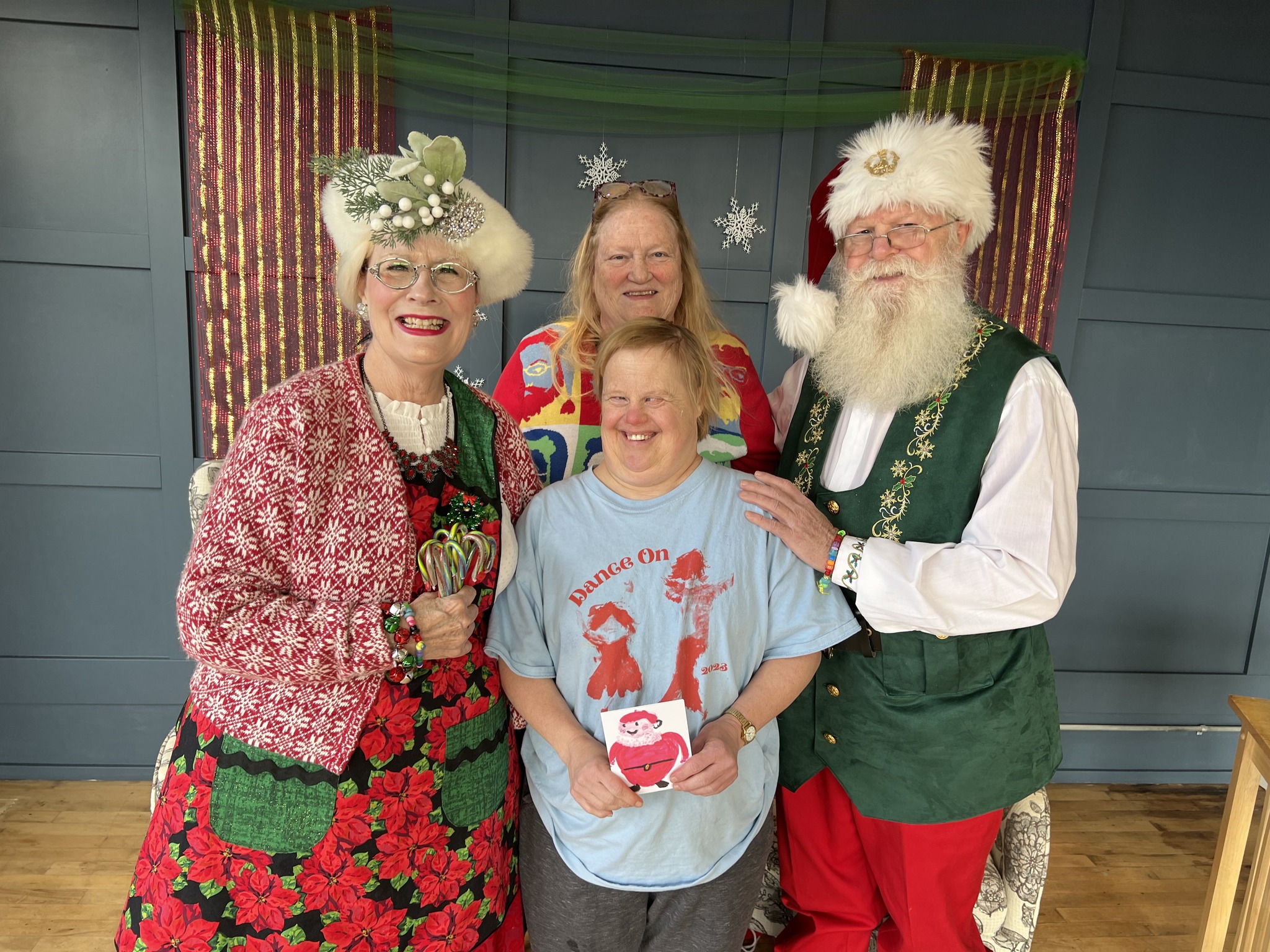 Founder Delight Lester and student standing with two persons portraying Santa Claus and Mrs. Claus